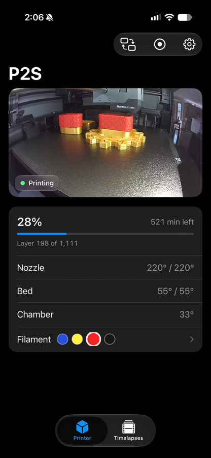 The AmbientCast dashboard on iPhone: the printer's live camera feed above print progress, temperatures, and the AMS filament row.